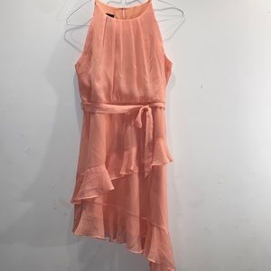 Light coral (apricot) Angled, ruffled, sleeveless dress.